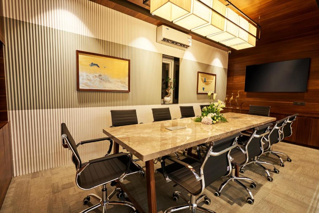 a conference room with a large table and chairs at Visthara Hotel in Bengaluru