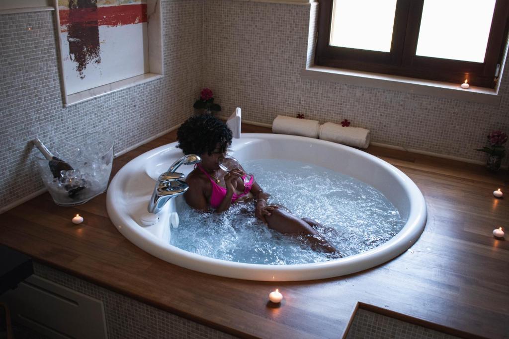 - une petite fille assise dans une baignoire dans la salle de bains dans l'établissement Villa Pietra Bianca, à Trani