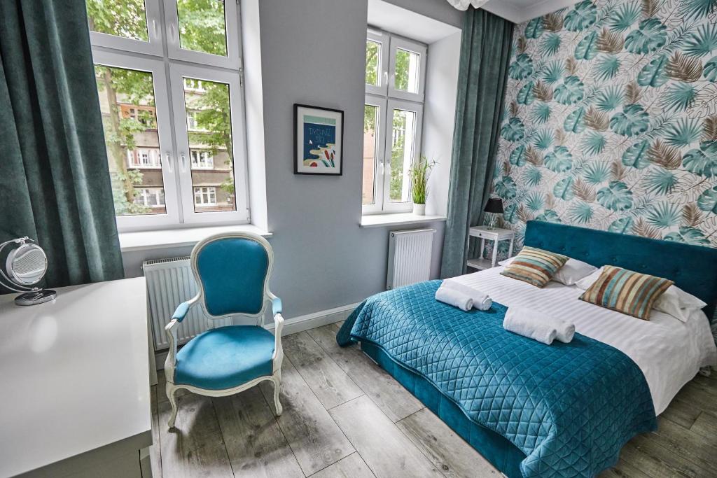 1 dormitorio con 1 cama azul y 1 silla azul en Niebieski Apartament DE LUX dla 4 osób Chorzów Katowice en Chorzów