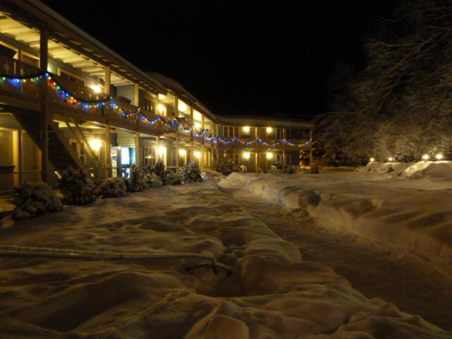 a snow covered street in front of a building with lights at Viking Motel in Wilmington