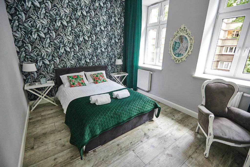 a green bedroom with a bed and a chair at Zielony Apartament DE LUX dla 4 osób Chorzów Katowice in Chorzów