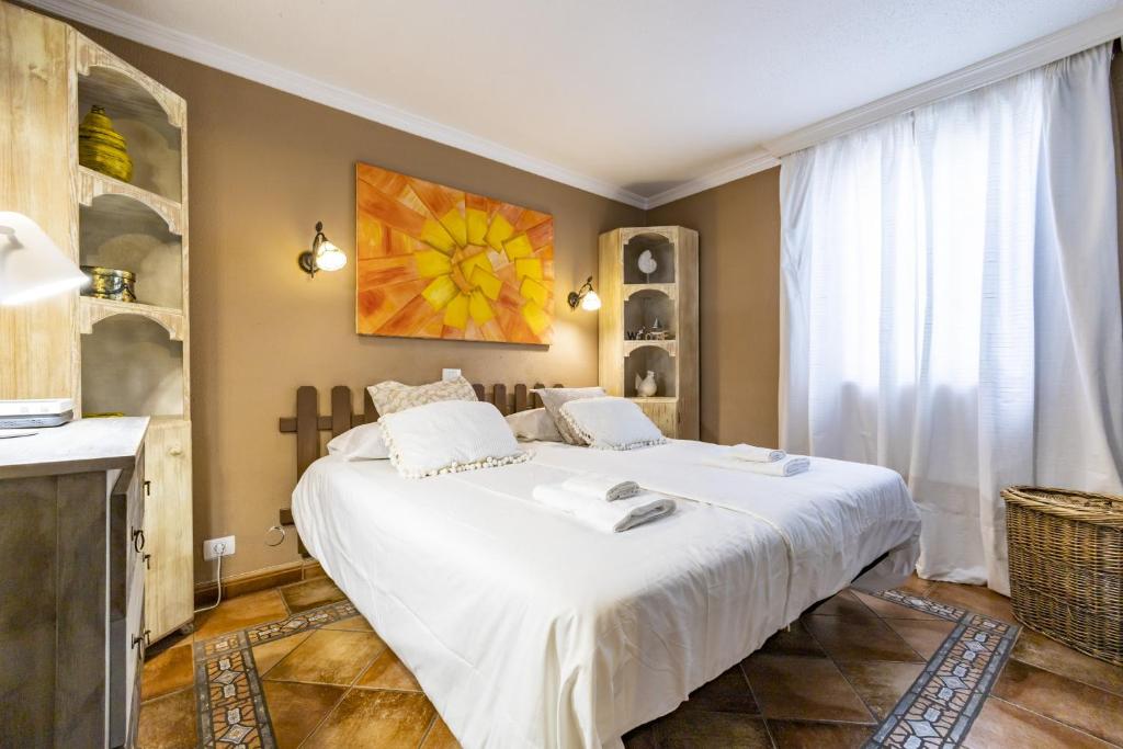 ein Schlafzimmer mit einem großen weißen Bett in einem Zimmer in der Unterkunft Bonito y acogedor apartamento con terraza in Los Realejos