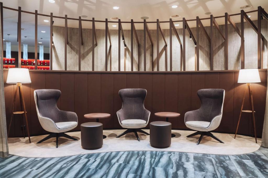 uma sala de espera com três cadeiras e duas mesas em Dorint Airport-Hotel Zürich em Glattbrugg