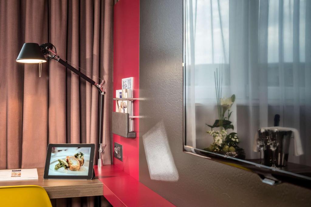 Uma televisão e/ou sistema de entretenimento em Dorint Airport-Hotel Zürich