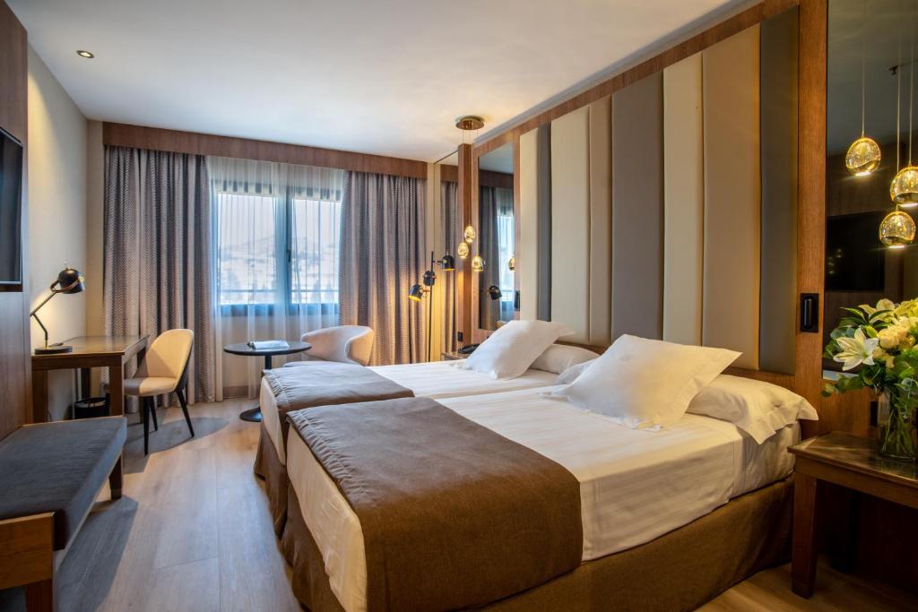 een hotelkamer met een groot bed en een bureau bij Hotel Granada Center in Granada