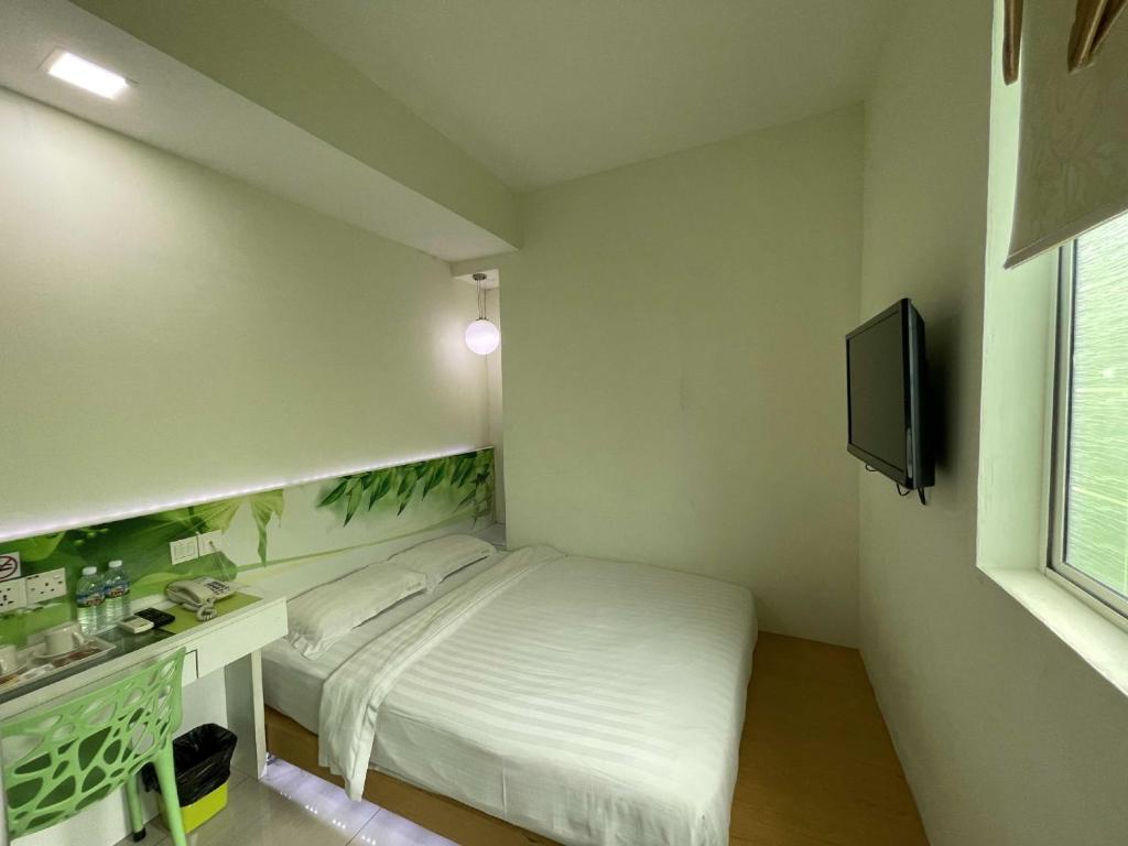 Kleines Zimmer mit einem Bett und einem TV in der Unterkunft Green Apple Boutique Hotel in Kota Kinabalu