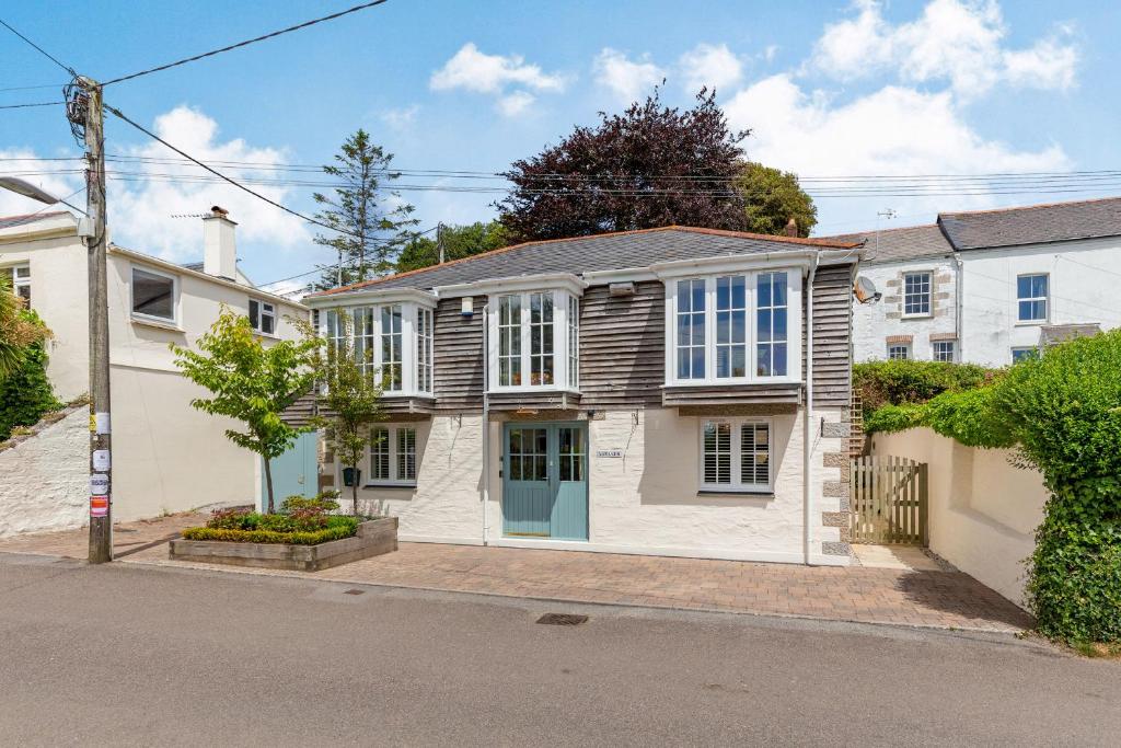 a white house with a blue door on a street at Armando in Truro
