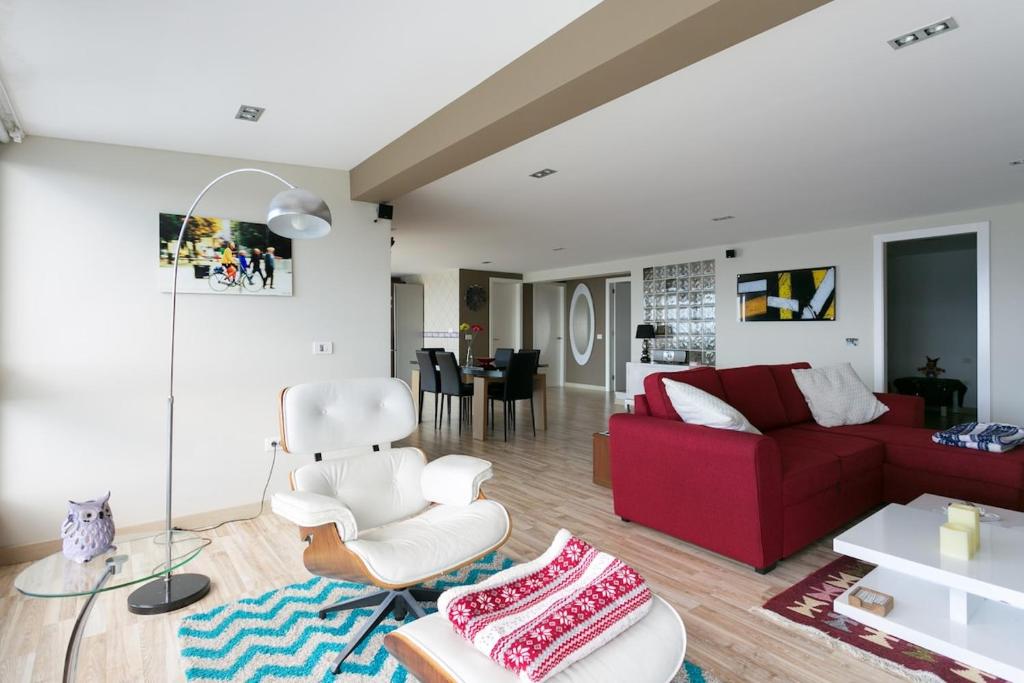 ein Wohnzimmer mit einem roten Sofa und einem roten Stuhl in der Unterkunft Nice and comfortable vacational apartment with sea view in Los Realejos