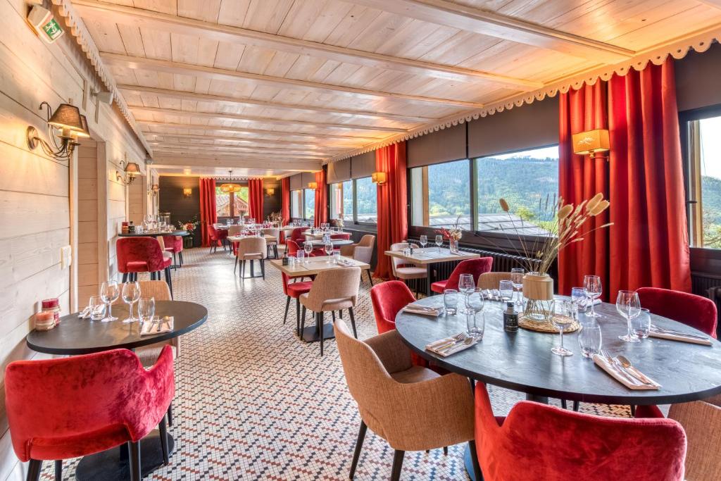 a restaurant with tables and chairs and windows at Hotel Le Bois Joli in Bernex