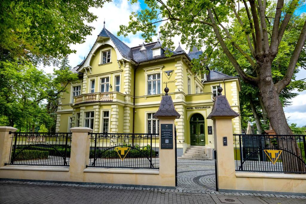 una casa amarilla con una puerta delante de ella en Villatoro, en Zgorzelec