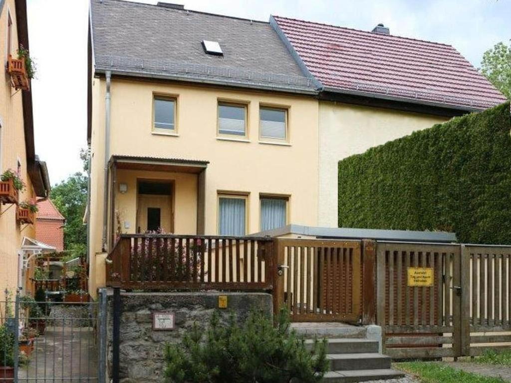 ein Haus mit einem Holzzaun davor in der Unterkunft Ferienhaus Ochsenauge in Weimar