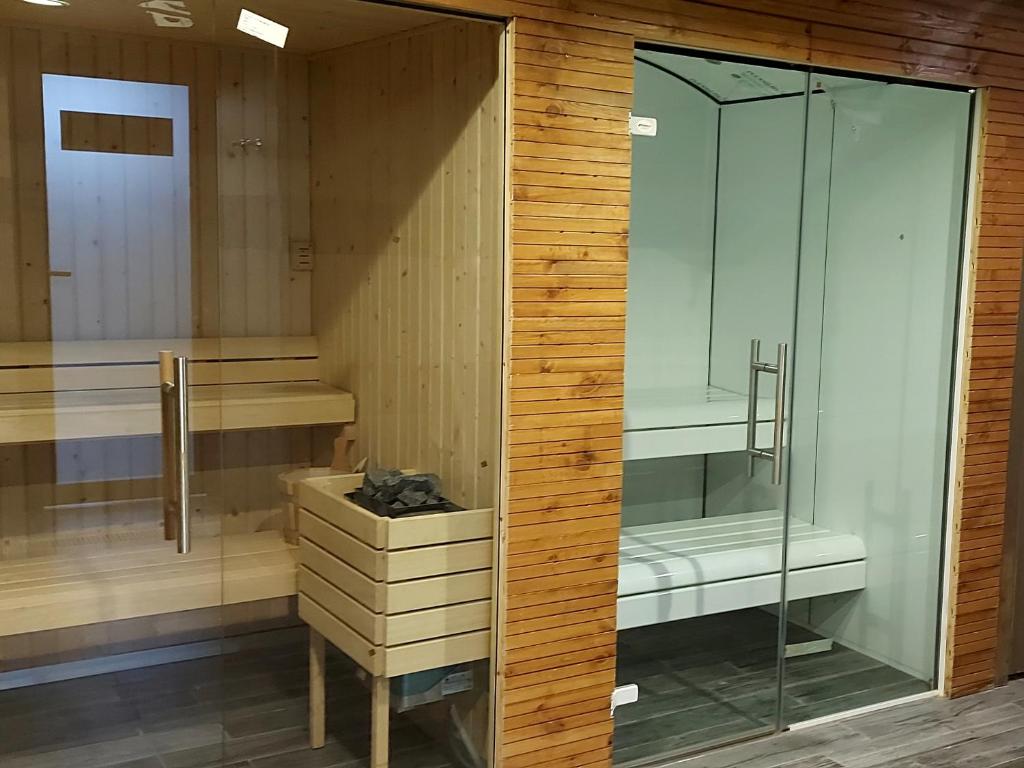 una sauna con paredes de madera y una puerta de cristal en El Ghanami Hotel en Argel