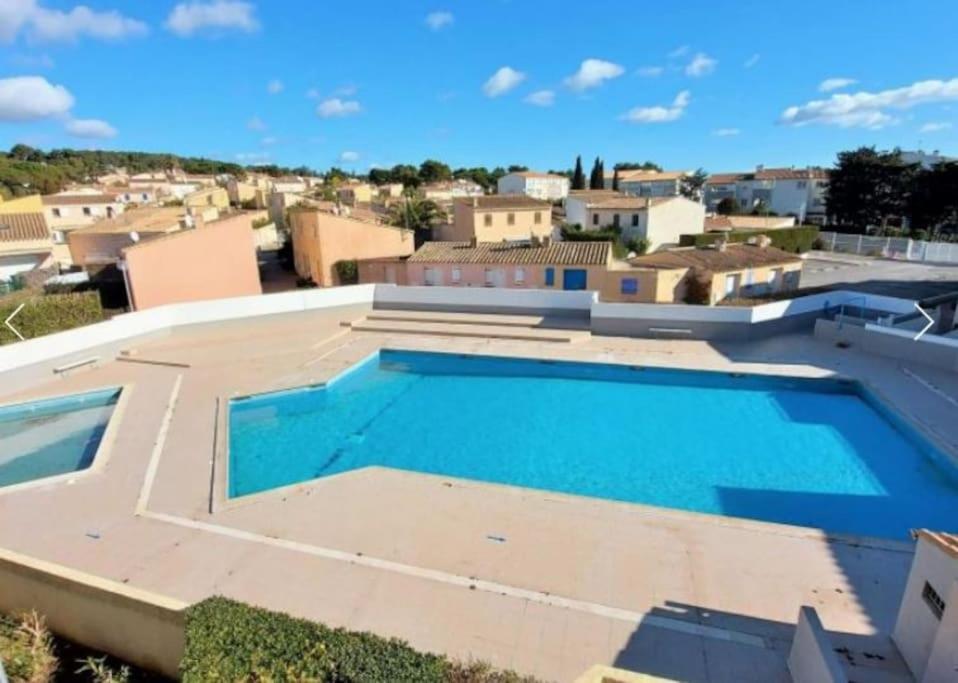 a large swimming pool on the roof of a house at Agréable Studio Cabine - piscine - parking - proche Plage RICHELIEU in Cap d'Agde
