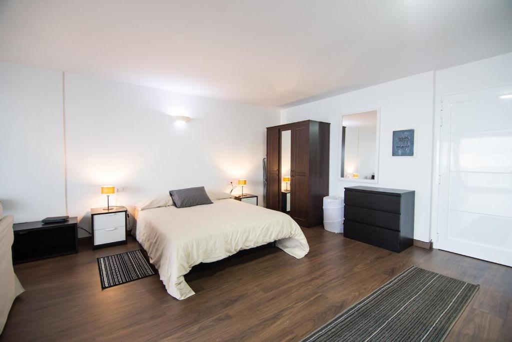 um quarto branco com uma cama e duas mesas de cabeceira em Cozy Studio with fantastic Sea View em Los Realejos