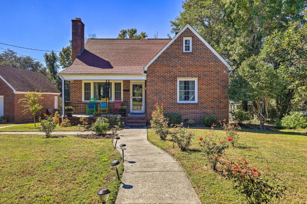 a brick house with a sidewalk in front of a yard at Convenient Jacksonville Home with Yard and Patio! in Jacksonville