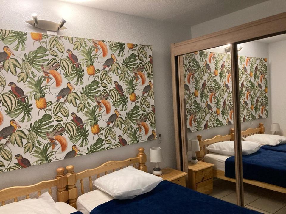 1 dormitorio con 2 camas y espejo en LES PIEDS DAND L'EAU, en Banyuls-sur-Mer
