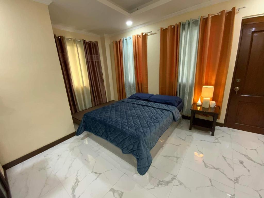 a bedroom with a bed with a blue comforter at Divine Resort Corporation in Moalboal