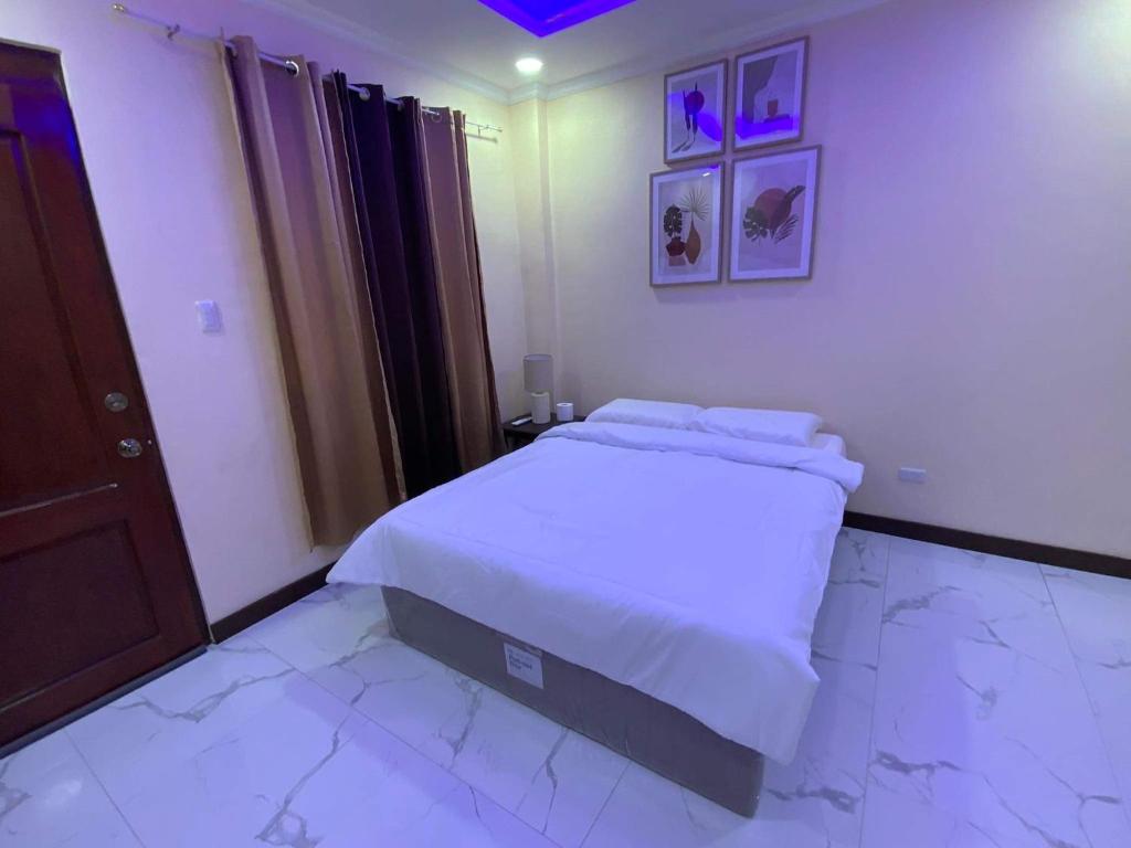 a bedroom with a bed with white sheets at Divine Resort Corporation in Moalboal
