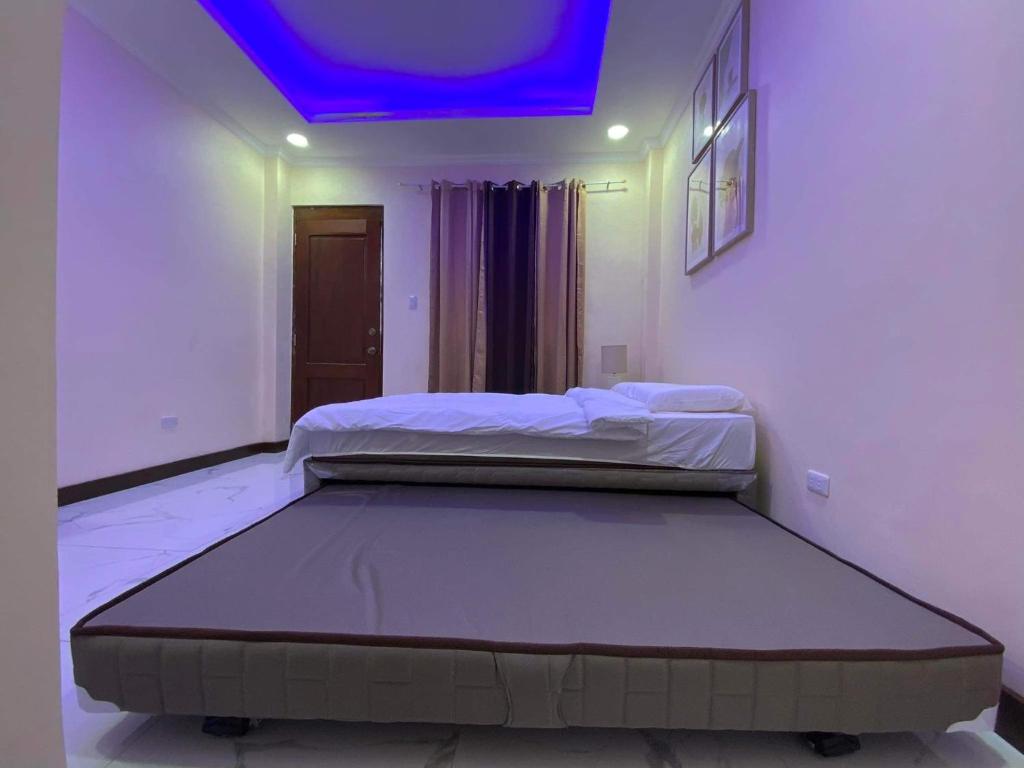 a bedroom with two beds and a blue ceiling at Divine Resort Corporation in Moalboal