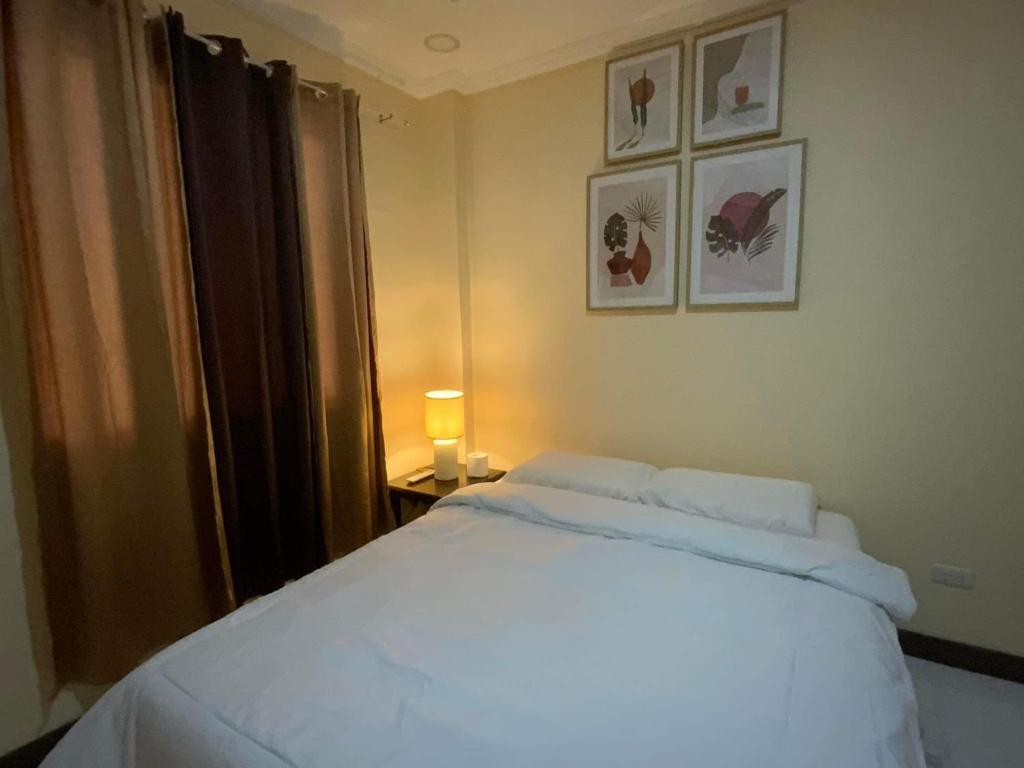 a bedroom with a white bed and a window at Divine Resort Corporation in Moalboal