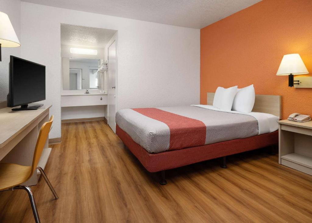 een kamer met een bed en een bureau met een televisie bij Motel 6-Buena Park, CA - Knotts Berry Farm - Disneyland in Buena Park