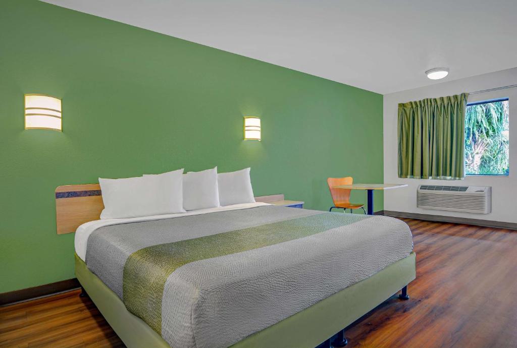 a bedroom with a large bed with a green wall at Motel 6-Tallahassee, FL - Downtown in Tallahassee