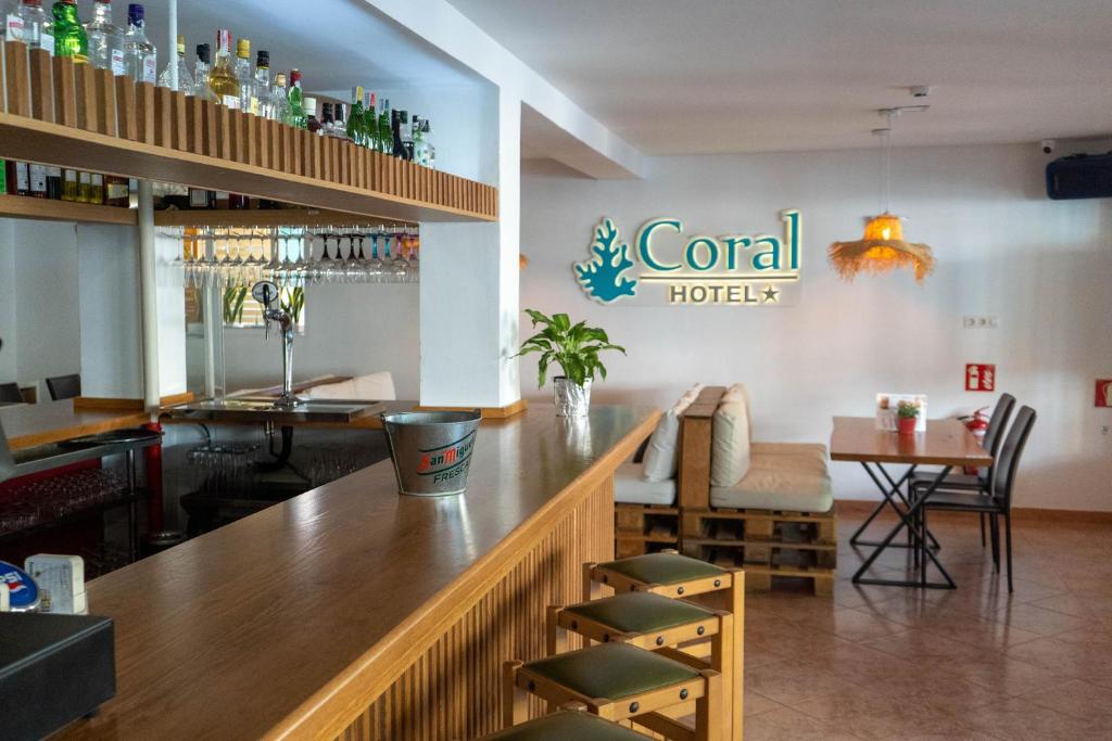a bar in a restaurant with a hotel sign on the wall at Coral beach house & food in Playa de Palma
