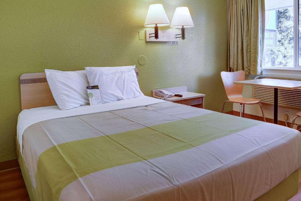 a bedroom with a large bed and a table at Motel 6-Eugene, OR - South Springfield in Eugene