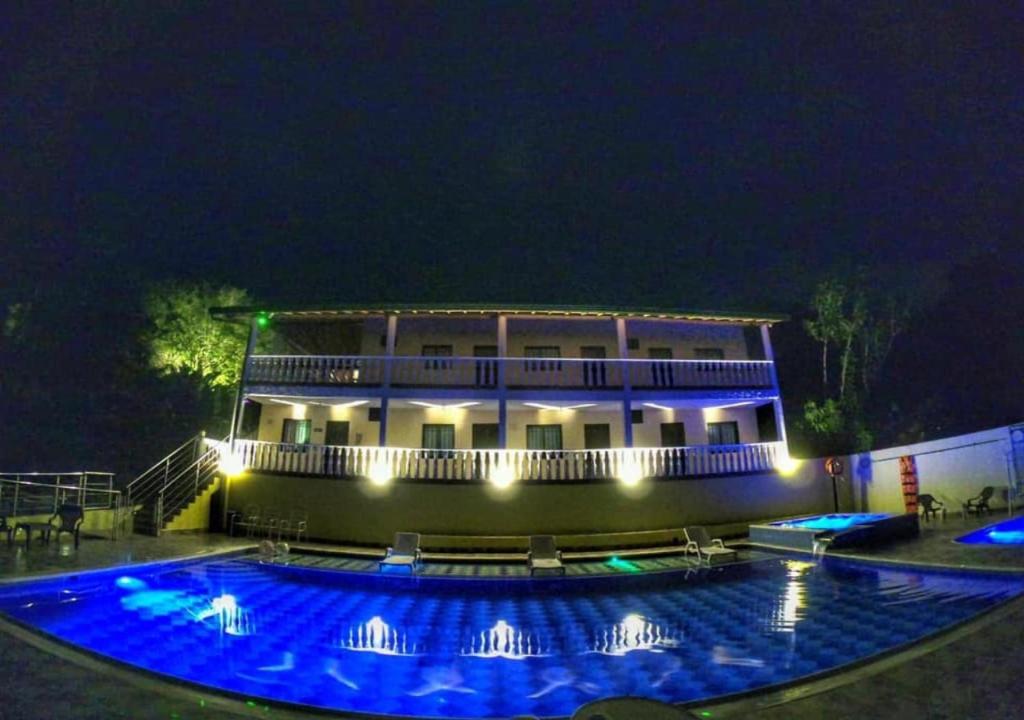 a building with a swimming pool at night at Natural Sea in San Gil