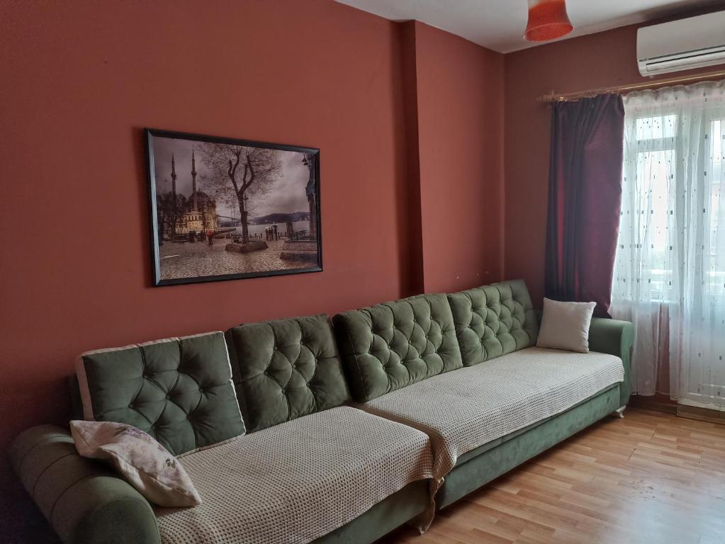 a green couch in a living room with red walls at EVA GOLD APART in Antalya