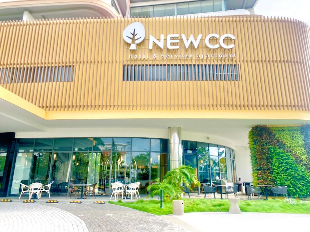 a newgc building with tables and chairs in front of it at NEWCC HOTEL AND SERVICED APARTMENT in Quang Ngai