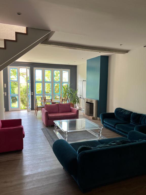 uma sala de estar com sofás e uma mesa de vidro em DE LA CROIX em Nanterre