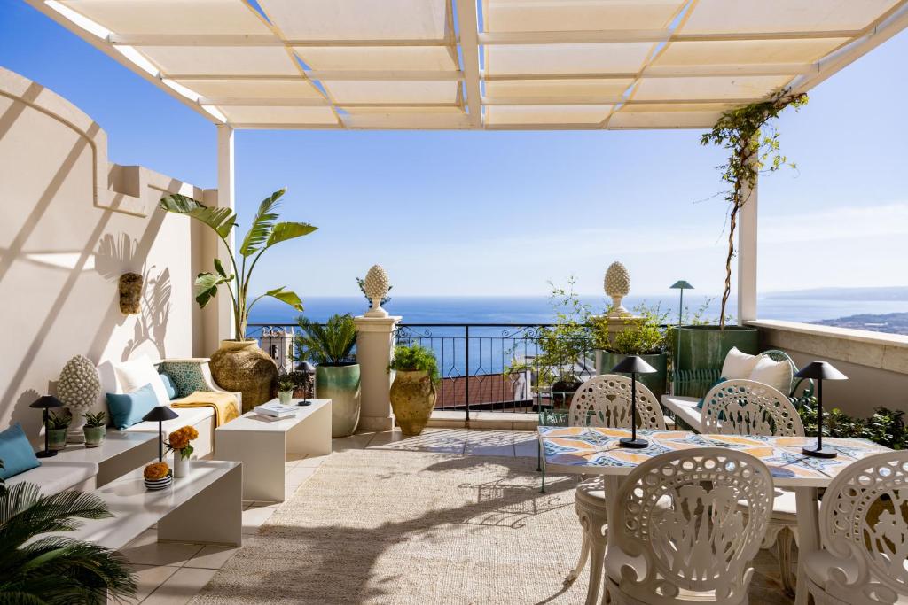 a patio area with chairs, tables and umbrellas at Taodomus Small Boutique Hotel in Taormina