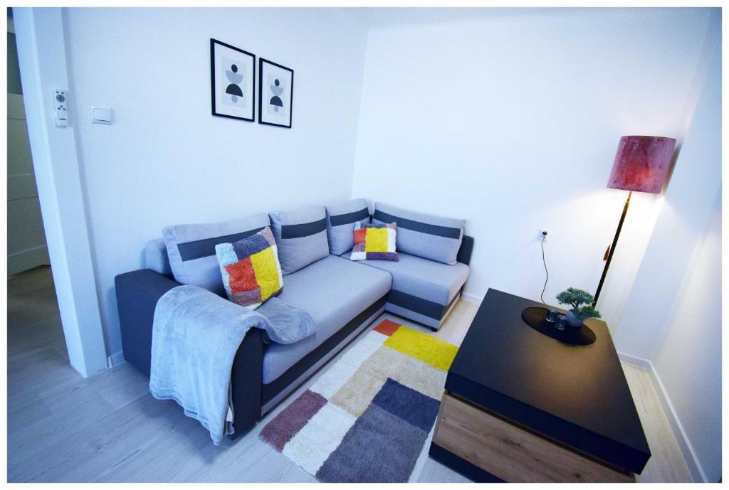 Nisko的住宿－Color24 Centrum Nisko，客厅配有蓝色的沙发和桌子