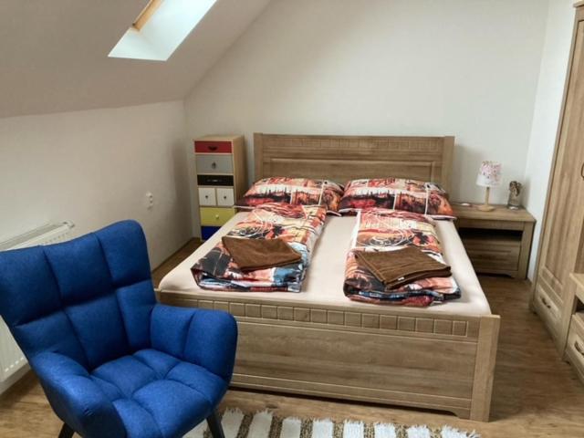 una camera da letto con un letto e una sedia blu di Dvojlôžková izba s vlastnou kúpelňou v priemyselnej zóne a Vranov nad Topľou