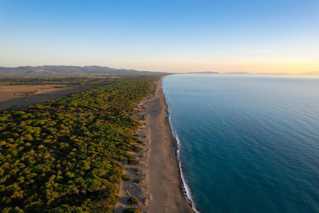 una vista aerea su una spiaggia e sull'oceano di Camping Il Capannino Glamping Village a Marina di Bibbona