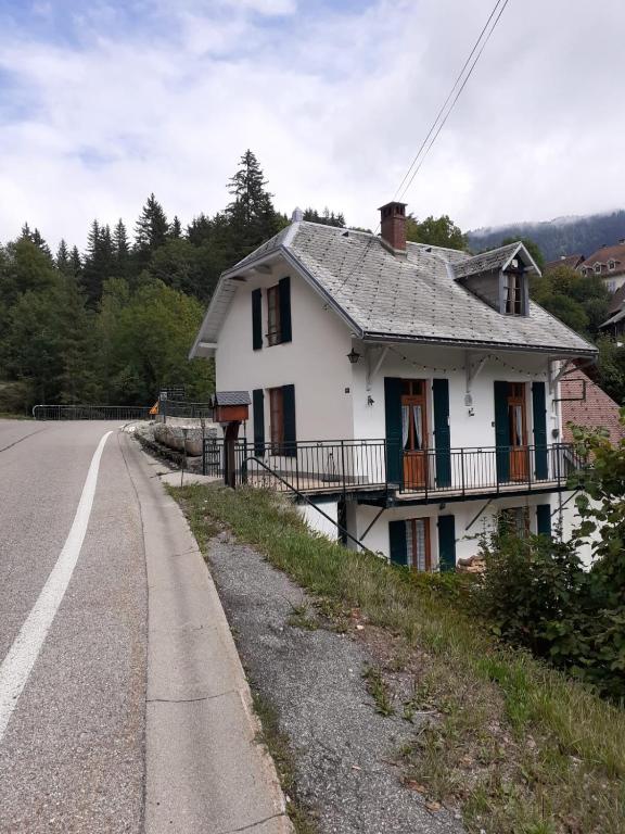 une maison blanche sur le côté d'une route dans l'établissement Maison du Guier 4 ou 6 personne au coeur du massif, à Saint-Pierre-de-Chartreuse