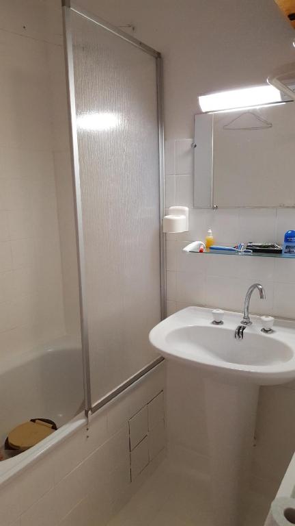 biała łazienka z umywalką i prysznicem w obiekcie Appartement au pied des pistes de st lary w mieście Saint-Lary-Soulan