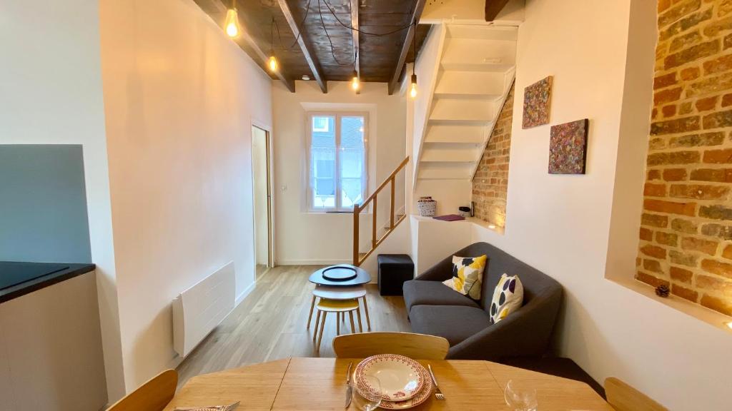 a living room with a couch and a table at Petite maison de pêcheur au coeur du Crotoy in Le Crotoy