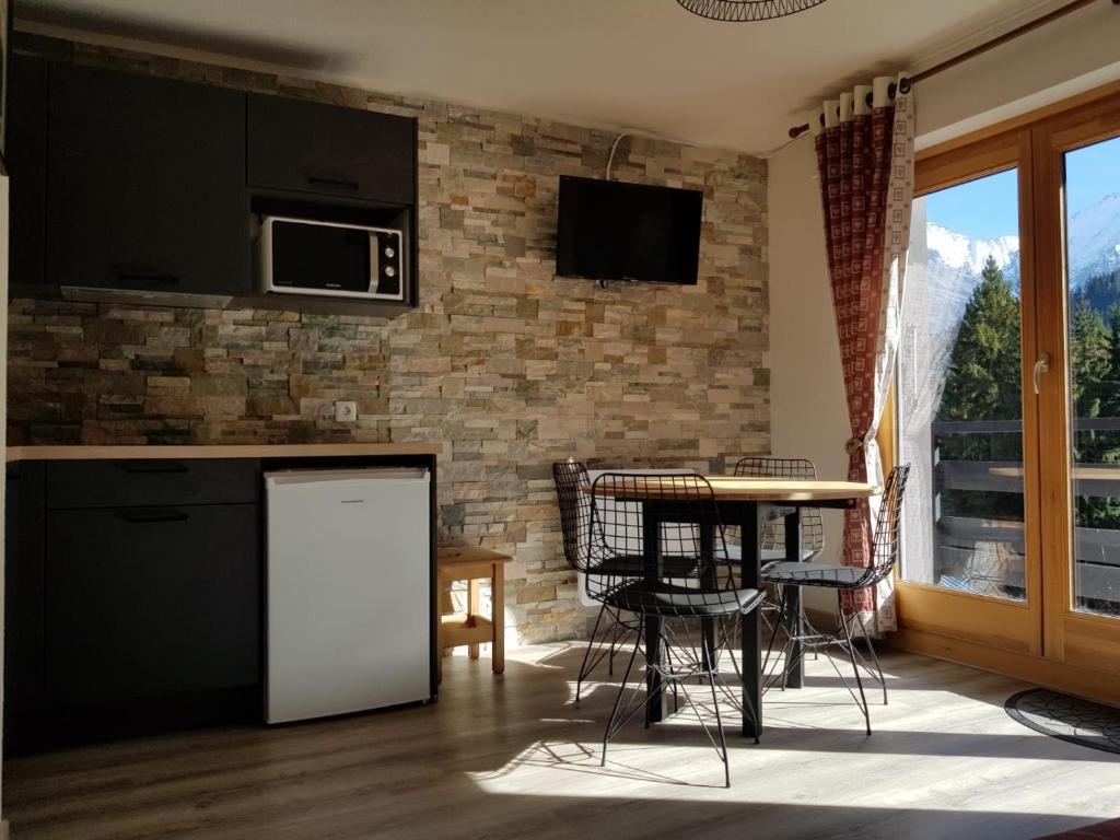 une cuisine avec un comptoir et une table avec des chaises dans l'établissement Appartement Saint Gervais les Bains piscine et vue imprenable Mont Blanc, à Saint-Gervais-les-Bains