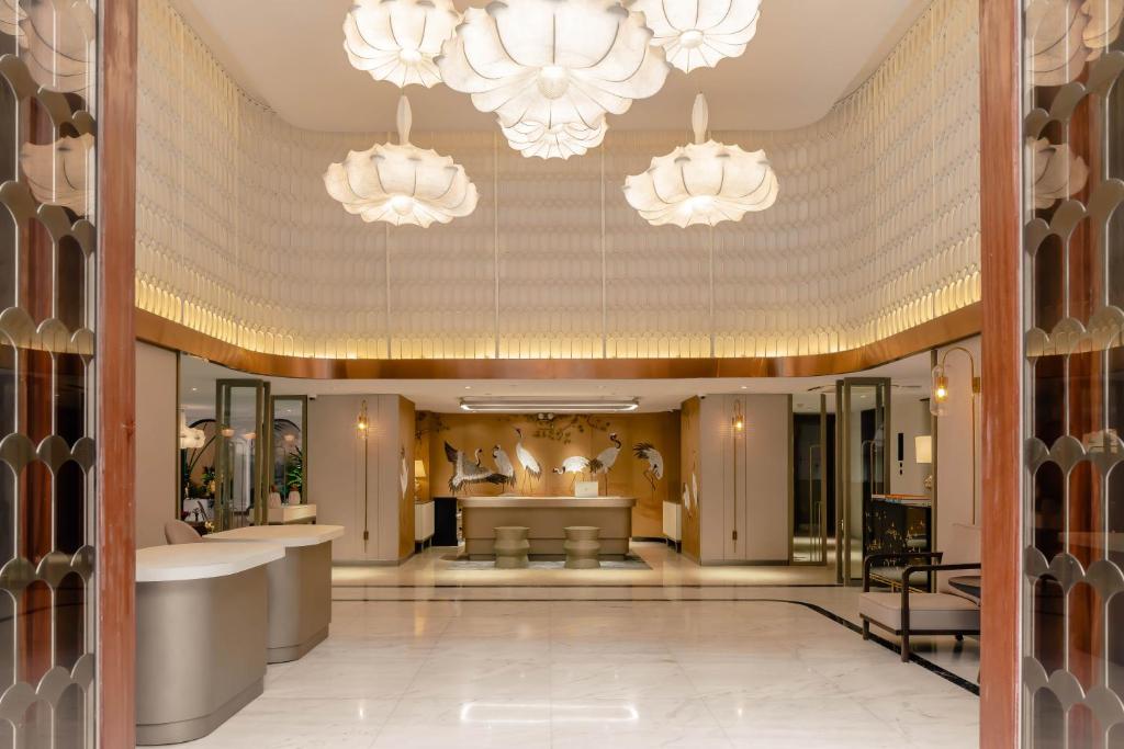 een lobby met 2 kroonluchters en een salon bij Hanoi Le Jardin Hotel & Spa in Hanoi