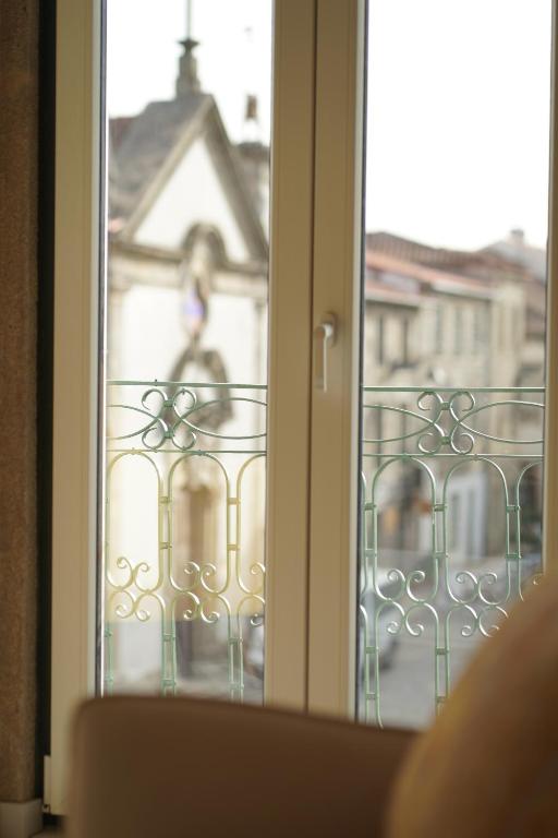 an open window with a view of a building at Burgo House in Trancoso