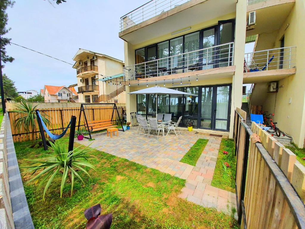 a house with a patio with a swing at beachfront apartments ,,kapro-one,, in Ureki