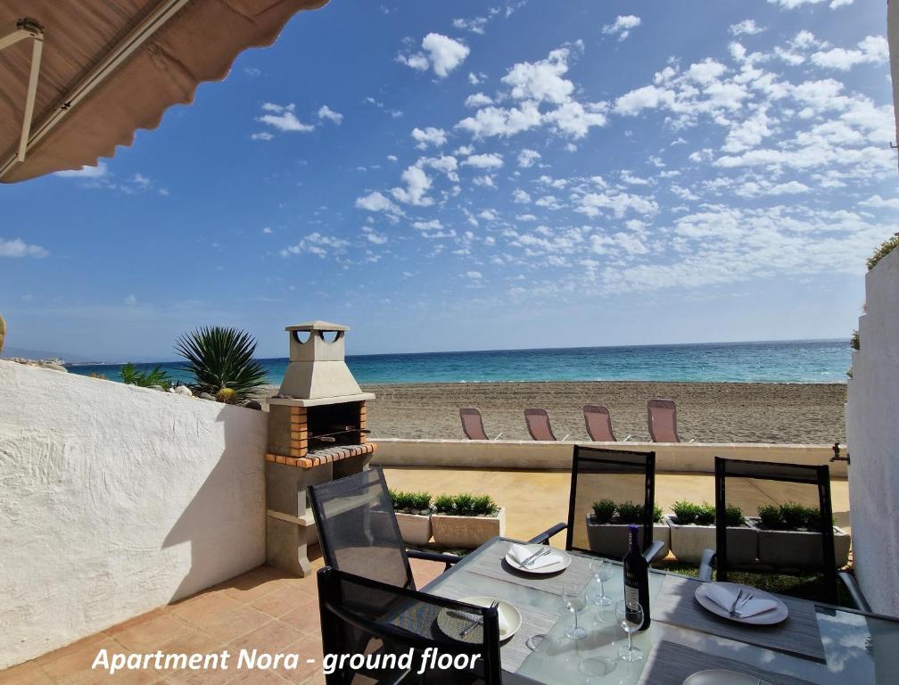 een patio met een tafel en stoelen en het strand bij Apartments Bahia Dorada in Estepona