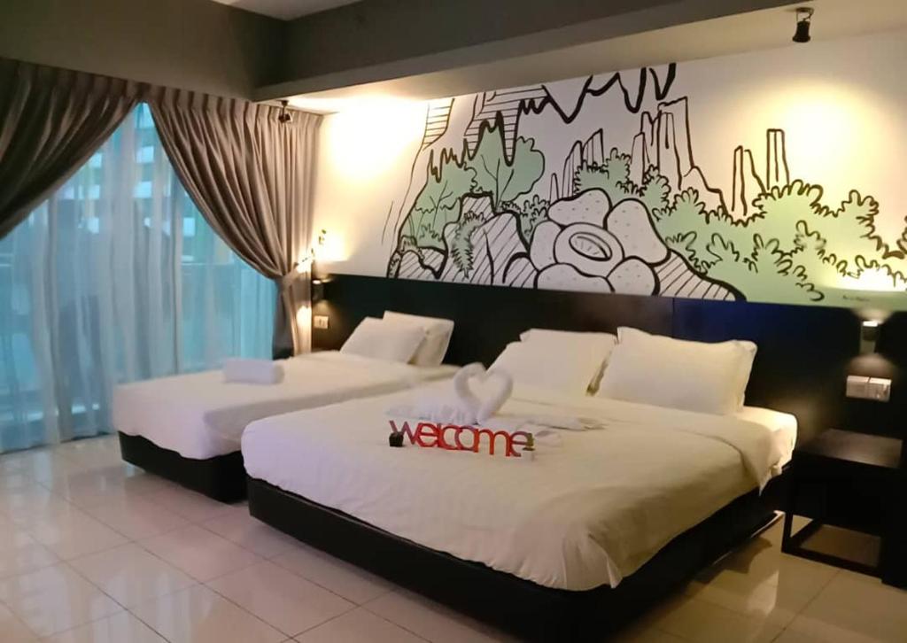 two beds in a hotel room with a mural on the wall at Aeropod Sovo-Star Suite in Kota Kinabalu