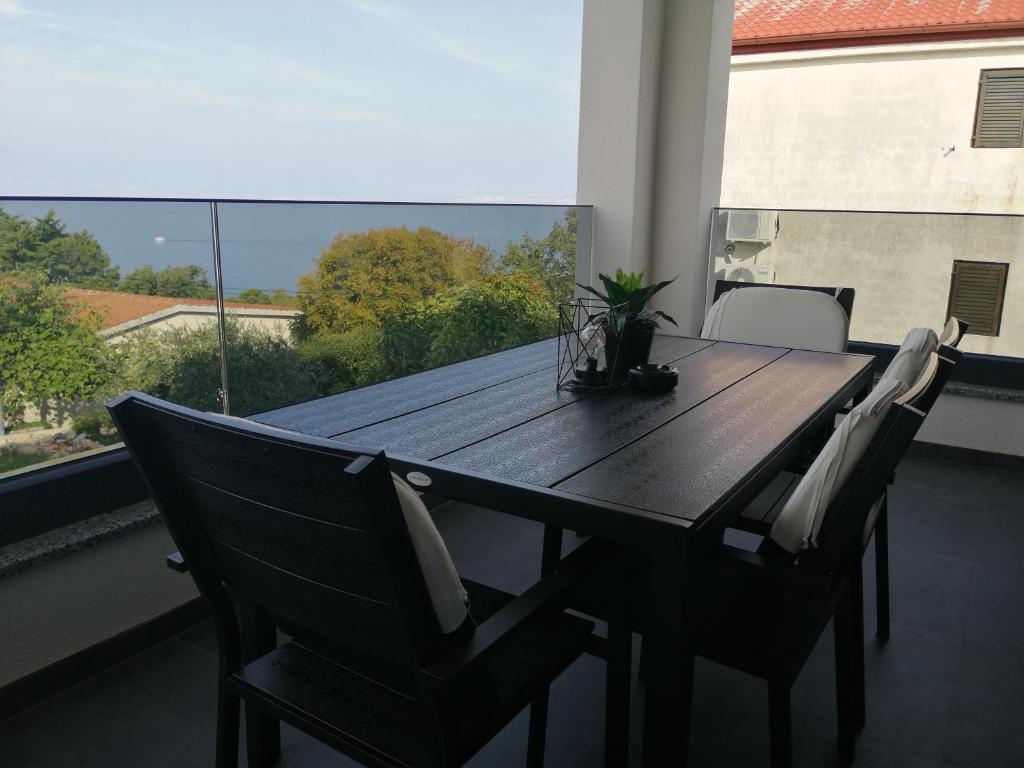 einen schwarzen Tisch und Stühle auf dem Balkon in der Unterkunft Golden Sunset 2 in Njivice