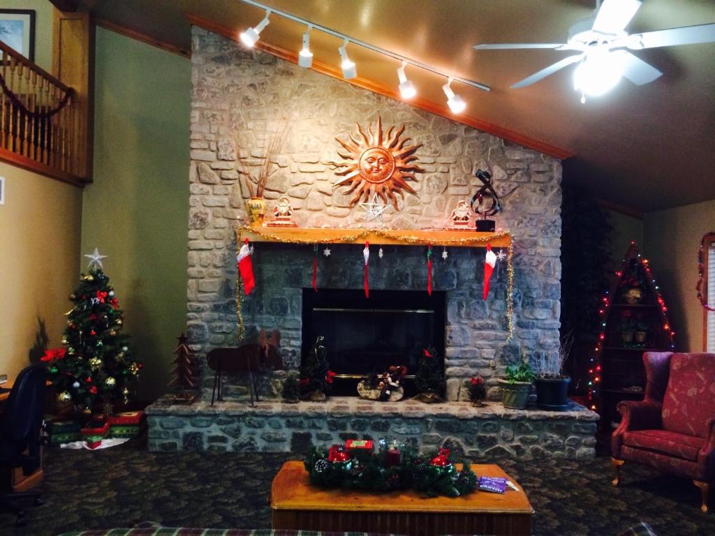 sala de estar con árboles de Navidad y chimenea en Regency Inn and Suites, en Stilwell