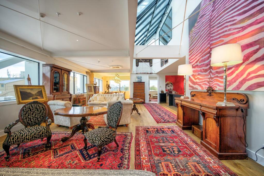 a living room with a table and a piano at The Address Napier in Napier