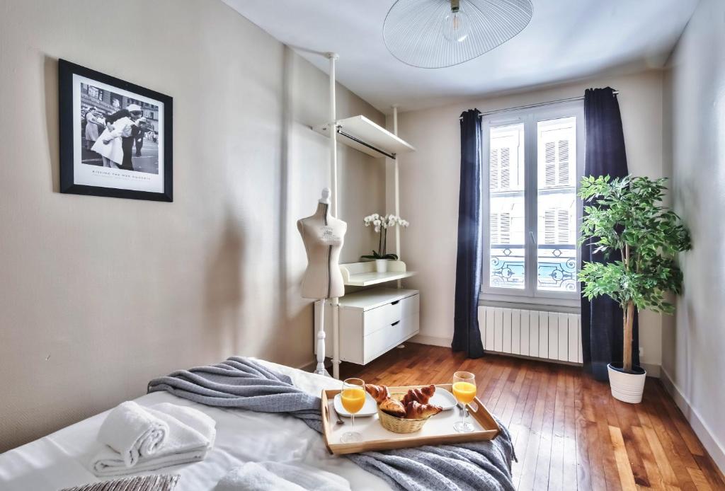 een slaapkamer met een dienblad met eten op een bed bij 831 - Near South Arena in Paris Olympic Games 2024 in Parijs