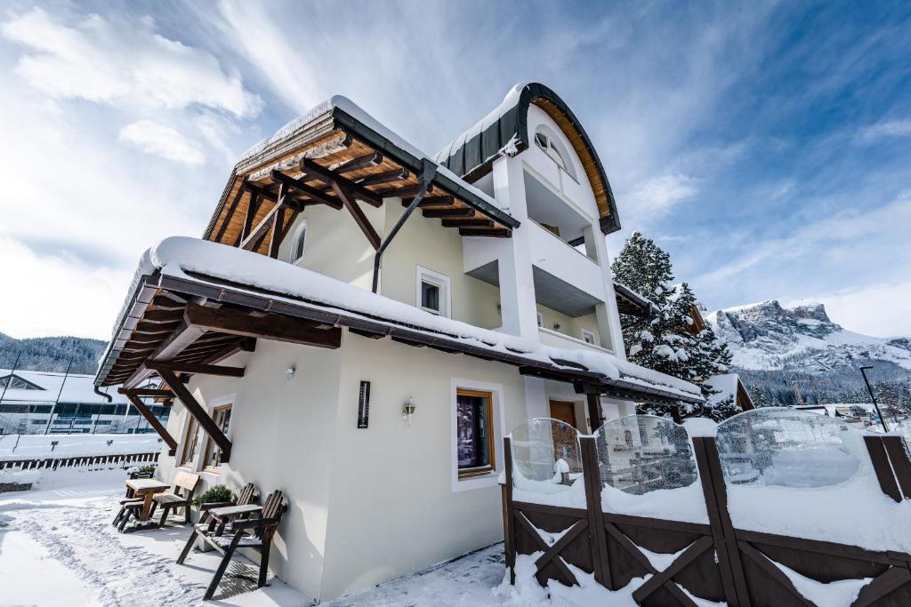 un edificio en la nieve con nieve en dalaNat, en Corvara in Badia